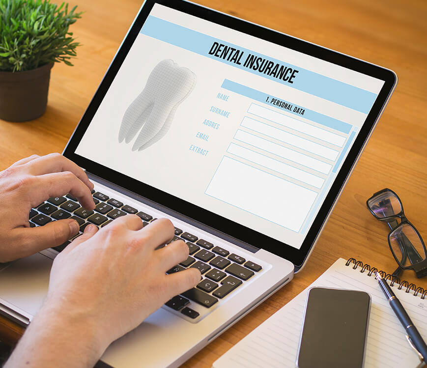 person looking up dental insurance information on their laptop